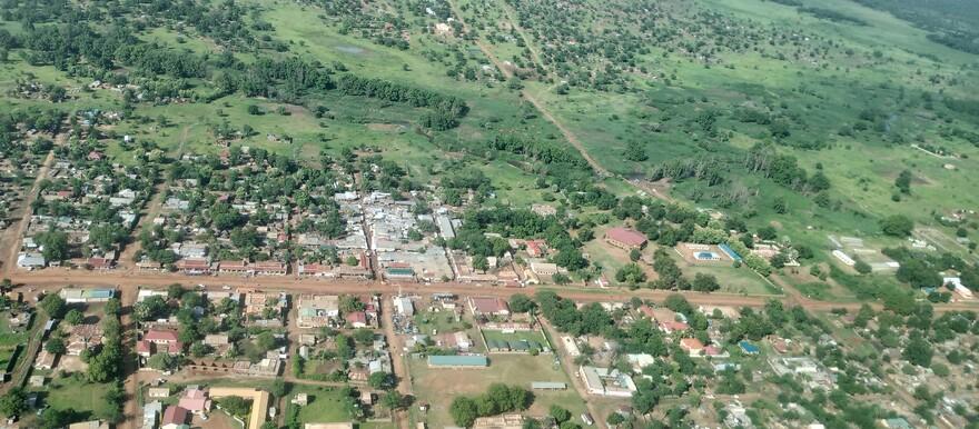 Aerial view of a town surrounded by green hills